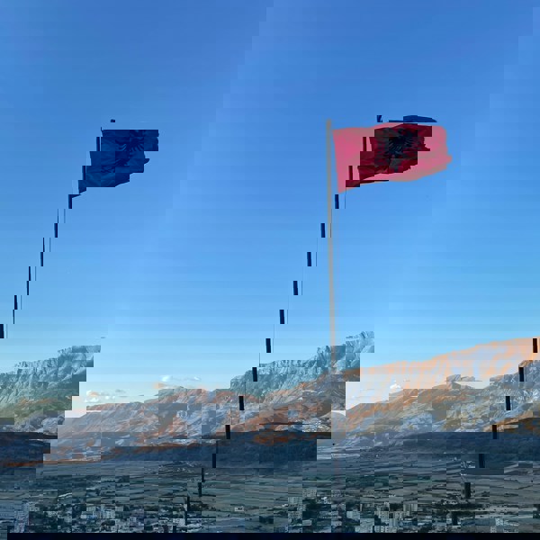 Udsigt over bjergene med Albaniens flag i forgrunden
